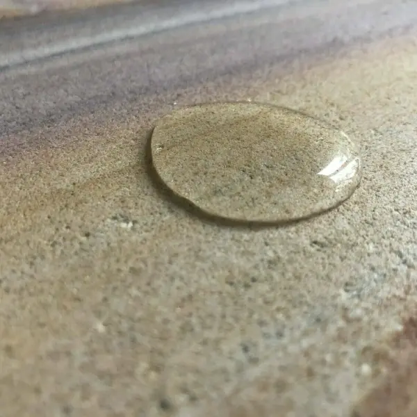 this is a water droplet beading on a rainbow sandstone tile after being sealed from HR Total Finish Matt