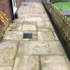 Algae-covered rainbow sandstone patio before HR Total Power Clean treatment.