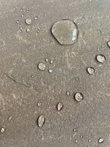 Close-up of water droplets beading on riven sandstone surface treated with HR Total Finish Matt sealer.