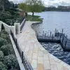 Freshly cleaned natural stone patio leading to a dock on a serene lakeside.