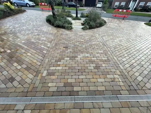 Wide view of a dry block paving driveway with vibrant natural color enhancement after treatment with HR Colour Enhancer patio sealer.