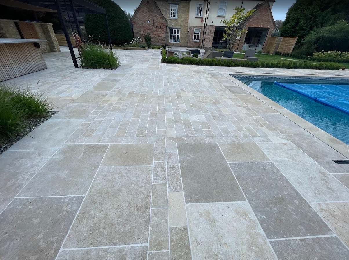Professionally cleaned and protected limestone patio surrounding an outdoor swimming pool